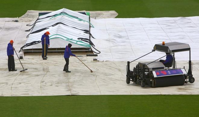 Los jardineros sacan el agua de las cubiertas cuando la lluvia retrasa el comienzo del juego antes del partido de la fase de grupos de la Copa Mundial de Críquet 2019 entre Bangladesh y Sri Lanka en Bristol County Ground en Bristol, Inglaterra.