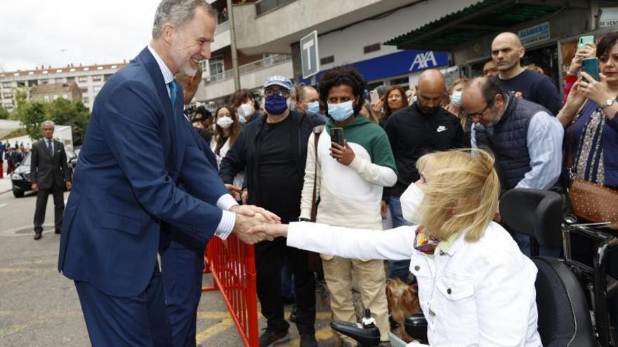 El monarca saluda a una de las ciudadanas que esperaba junto a la Ciudad de la Justicia