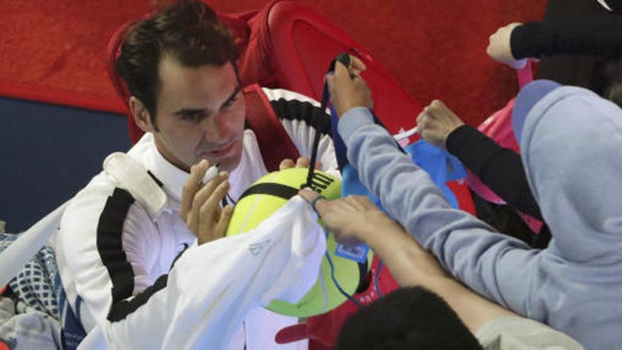 Federer firma autógrafos a los aficionados tras su partido ante Wawrinka