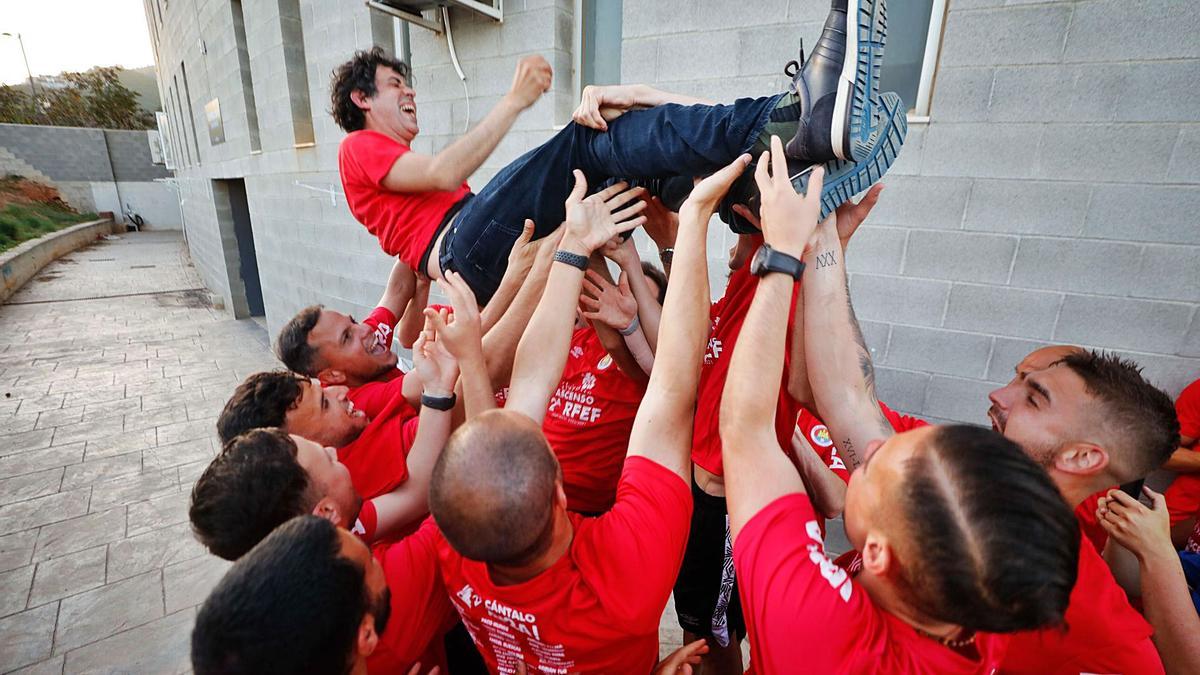 La plantilla rojiblanca mantea a Alberto Gallego, entrenador del CD Ibiza, celebrando por todo lo alto su salto de categoría. | FOTOS: JUAN A. RIERA