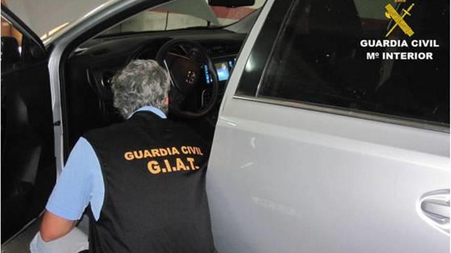Un guardia civil de Tráfico junto a uno de los vehículos bajo sospecha.