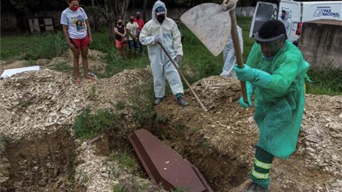 Familiares observan el entierro de un joven de 28 años muerto por coronavirus, en el cementerio Despraiado en Cuiabá, capital de Mato Grosso (Brasil).