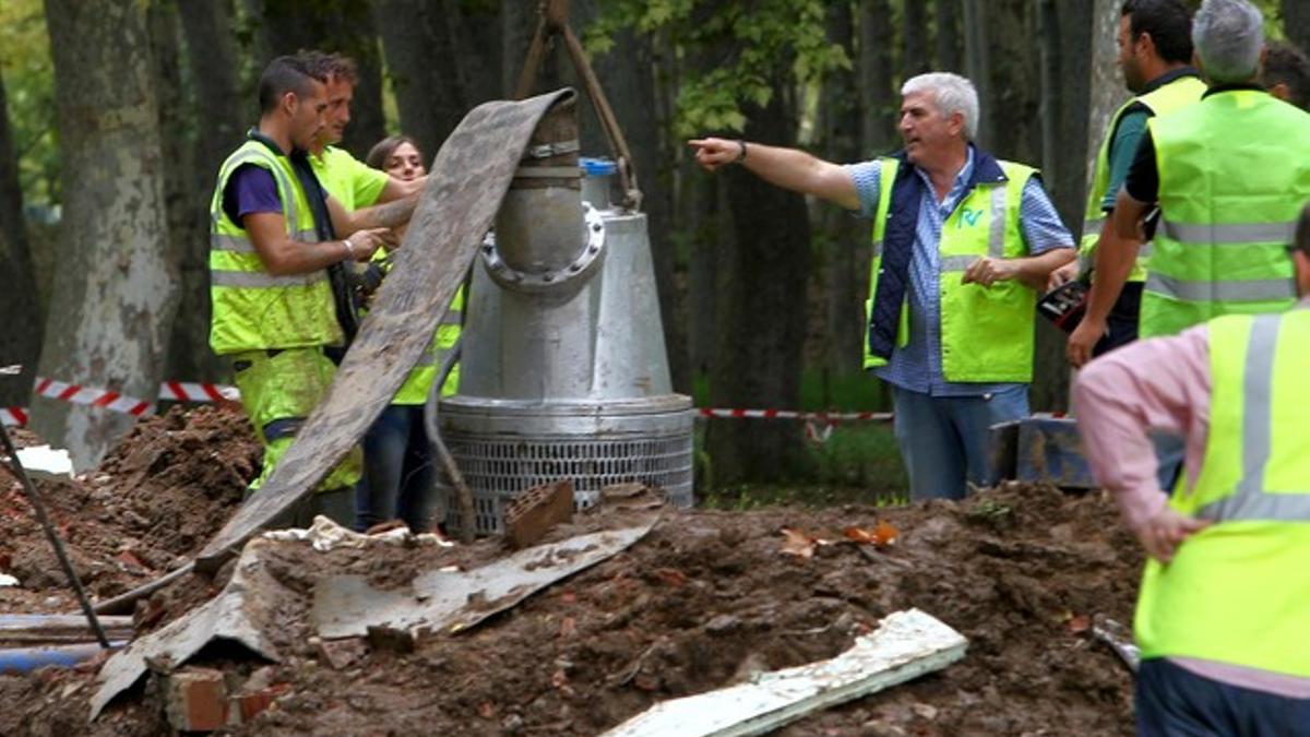 Un grupo de operarios extraen agua de la vía inundada, el martes en Girona.