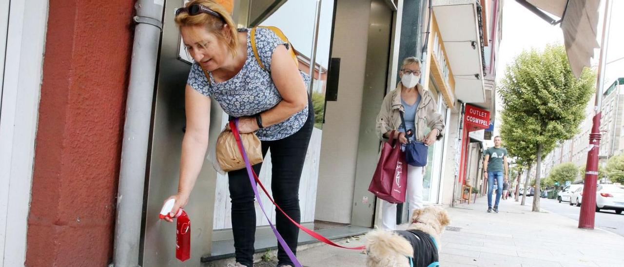 Una vecina utiliza el espray para limpiar los orines de sus mascotas en Sanjurjo Badía.