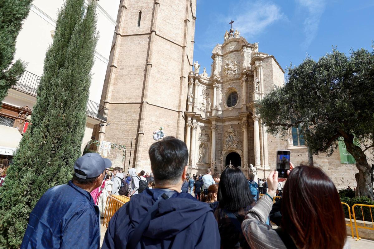 Turistas tomando fotos en la Plaza de la Reina de València.