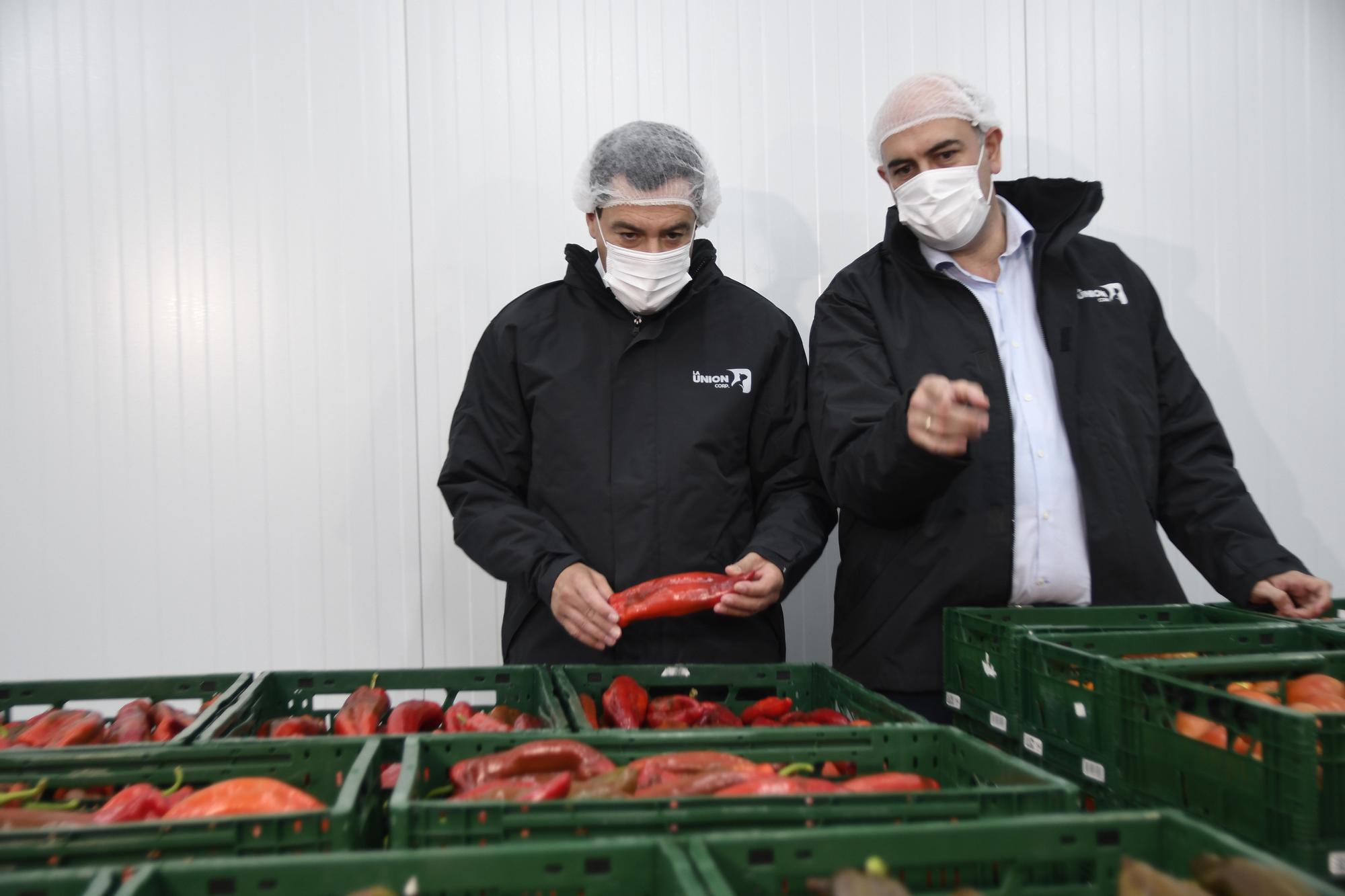 Juanma Moreno (i), durante su visita a la cooperativa La Unión, este viernes en Adra (Almería).