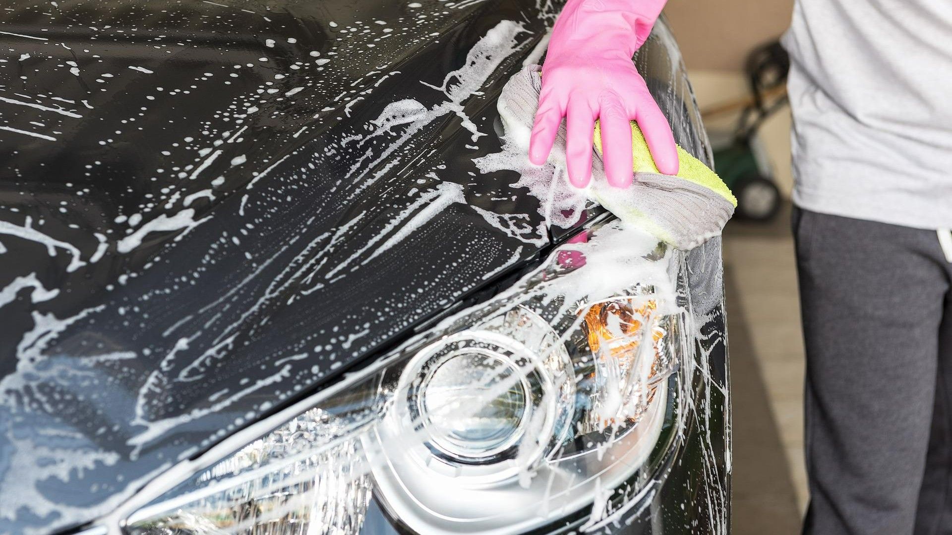 Un hombre lava un coche