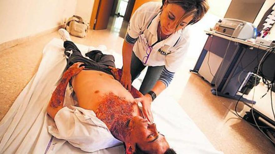 Rosa Encinas, ayer, con un joven que participó en los exámenes simulando ser un paciente con quemaduras graves.