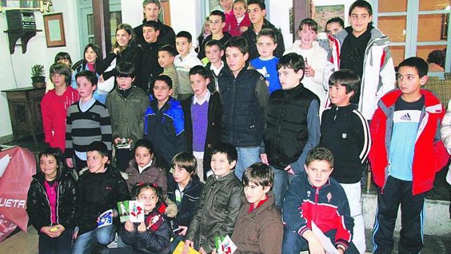 Juan Carlos Ferrero, al fondo a la izquierda, junto a los alumnos de las escuelas de tenis con los que mantuvo un encuentro ayer en Pravia.