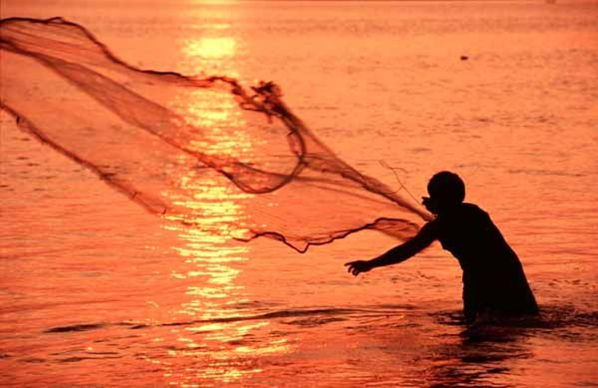 Un pescador lanza su red al atardecer en el rio Mekong a su paso por Pakxe.