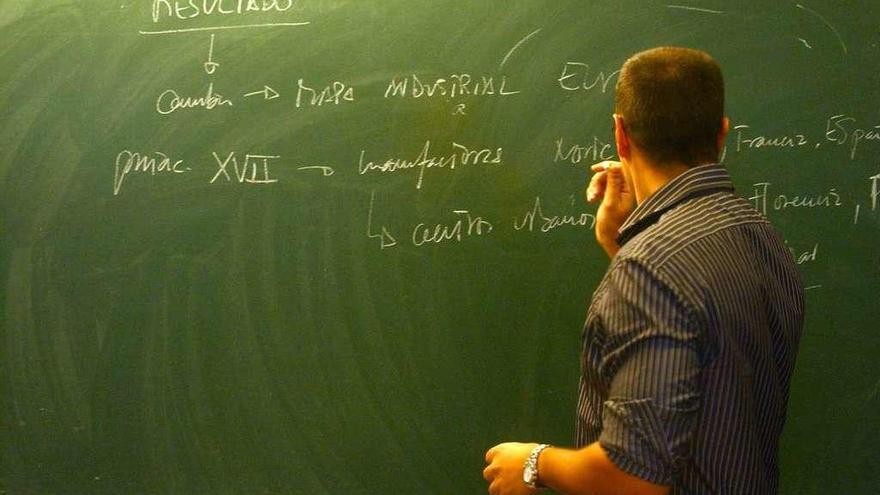 Un profesor escribe en la pizarra.