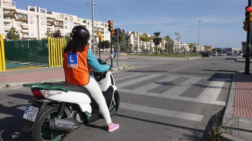 Una mujer realiza prácticas para aprender a conducir un ciclomotor.