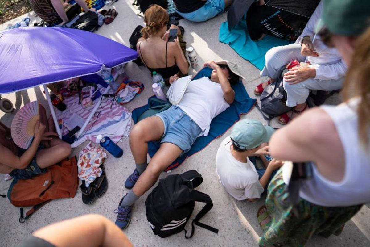 Visitantes y aficionados a la observación astronómica esperan en el Port de la Maria, en Tarragona, para contemplar el eclipse total de Sol.