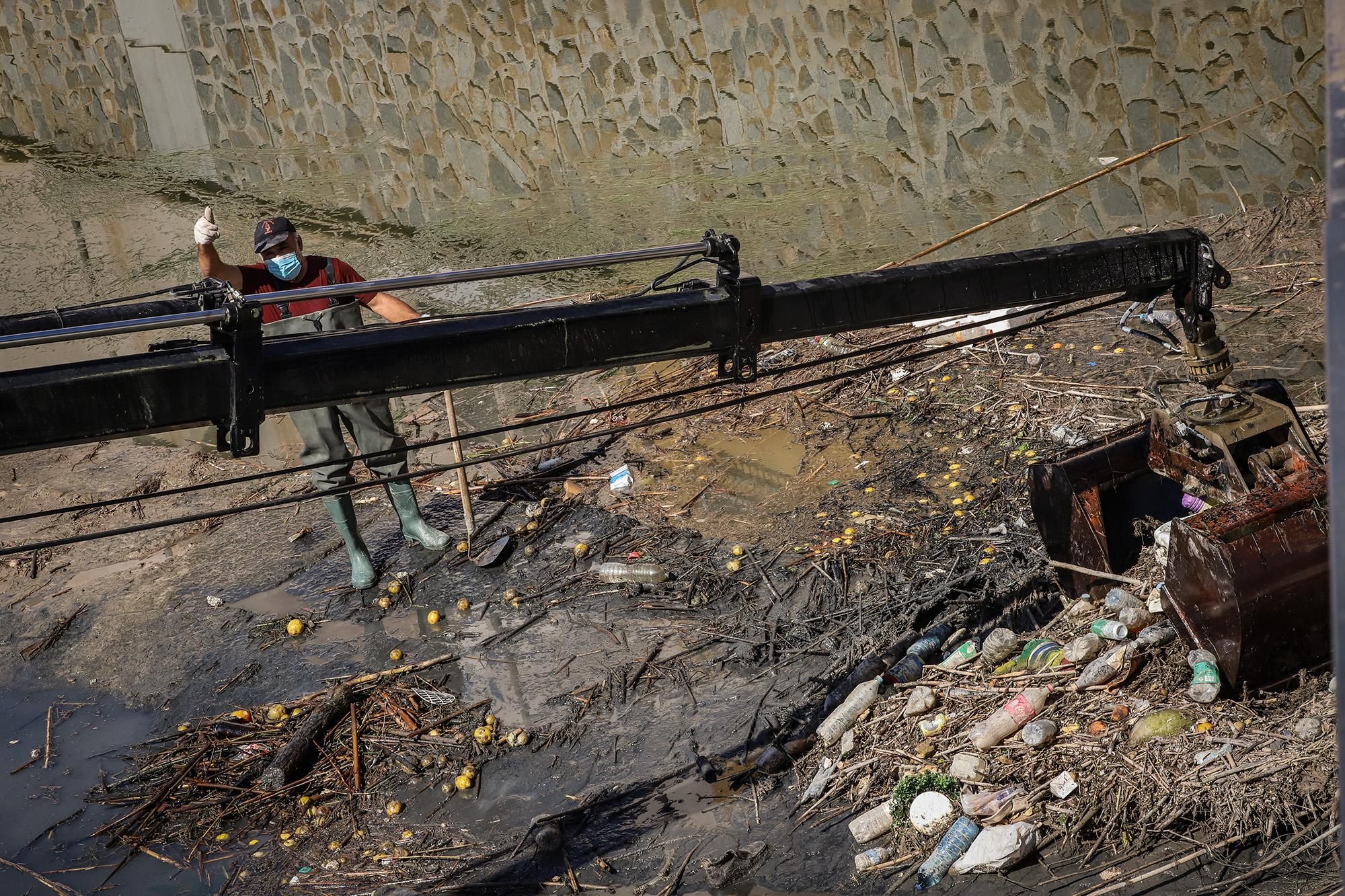 Un operario limpia el río