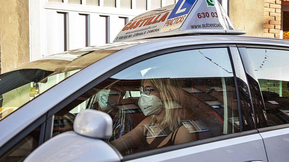 Una alumna inicia una clase práctica en la autoescula con las mascarillas obligatorias.