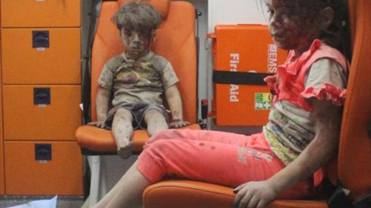 El pequeño Omran, de 5 años, junto a su hermana, tras ser rescatados de un edificio bombardeado el miércoles en Alepo.