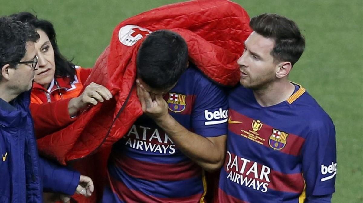 Messi consuela a Luis Suárez, que abandona el campo lesionado durante la final de la Copa del Rey entre el Barça y el Sevilla.