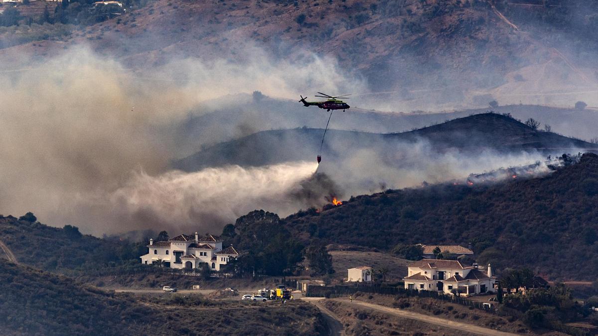 Un helicóptero trabaja en la extinción del  incendio forestal de Mijas