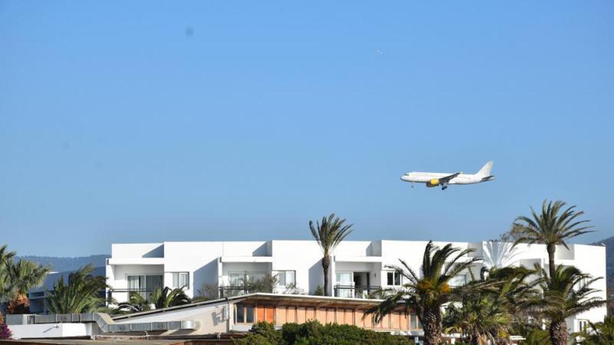 A Vueling plane flying over Platja d'en Bossa before landing at Ibiza airport.