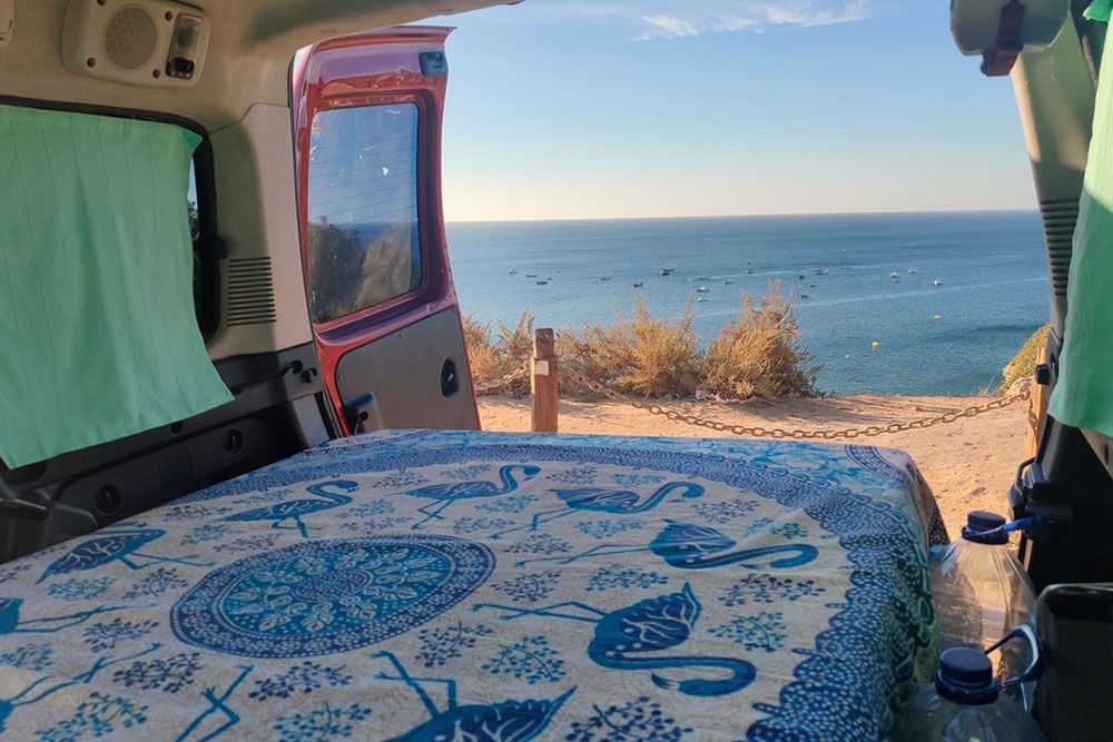 Carlos Cadilla y Lucía Pérez en su furgoneta camper en la playa de Cesantes