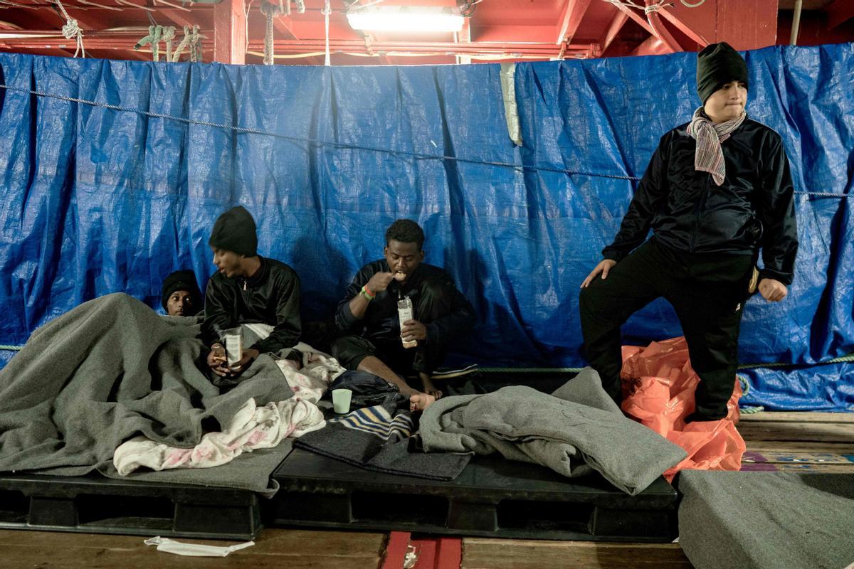 Migrantes descansando a bordo del barco de rescate Ocean Viking de la organización humanitaria marítima europea SOS Mediterranee en aguas internacionales en el golfo de Catania