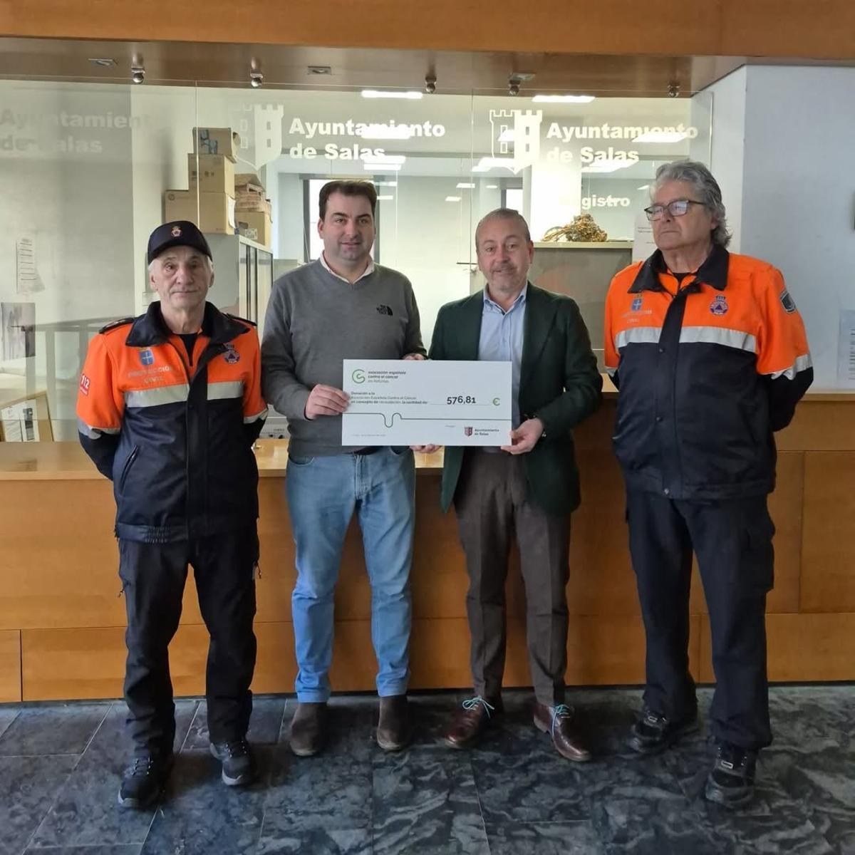 Sergio Hidalgo entrega el cheque de donativos navideños a Antonio Flecha junto a miembros de Protección Civil.