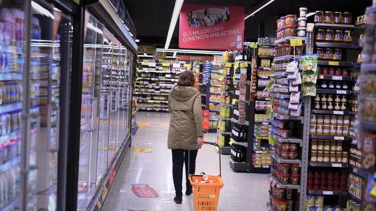 Una clienta deambula entre los estantes llenos de productos de un supermercado de Barcelona.