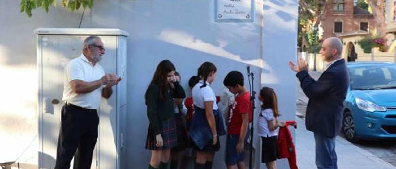 Un grupo de niños, bajo la placa del Carrer Mestra Amelia Ibáñez.