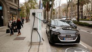 Un coche eléctrico se carga en un poste de recarga en Barcelona.