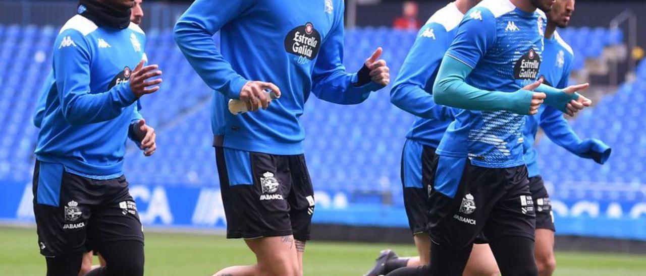 Borja Granero, en el centro, trota por el césped de Riazor. |  // V. ECHAVE