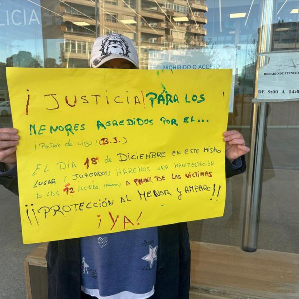 Una madre con un cartel sobre agresiones a menores, ayer, en los juzgados de Vigo.