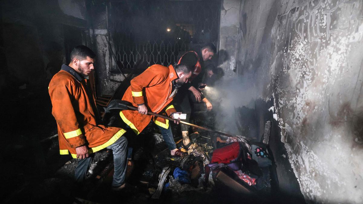 Bomberos palestinos extinguen un incendio en uno de los apartamentos del campo de refugiados de Jabalia, en el norte de la Franja de Gaza.
