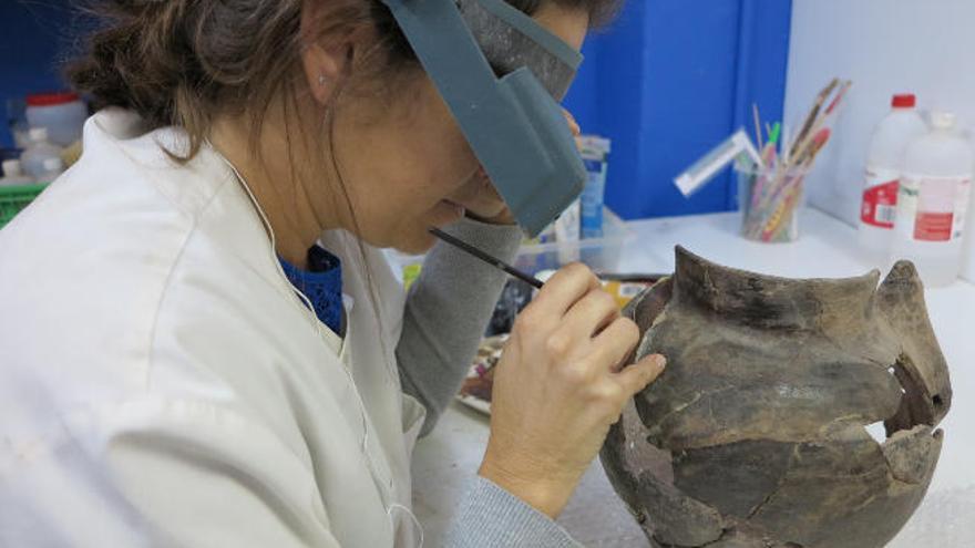 La restauradora Marta Bosch trabajando en la reconstrucción de una de las vasijas.