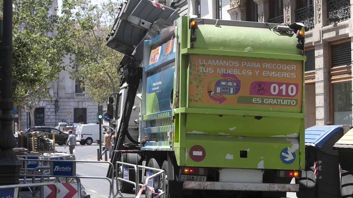 Un camión recoge un contenedor de basura en València.