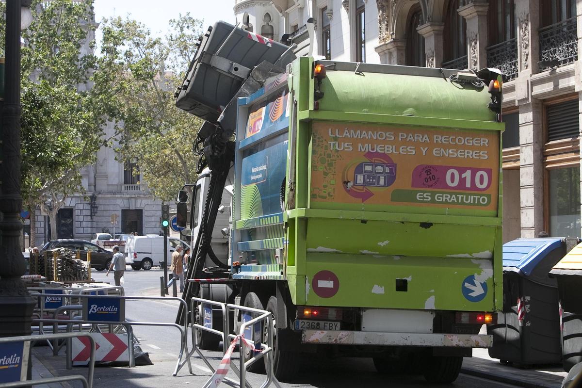 Un camión recoge un contenedor de basura en València.