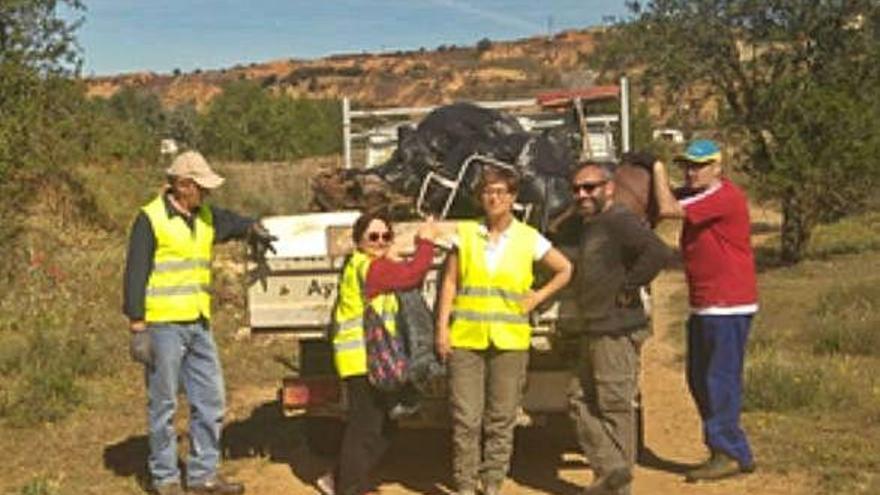 Voluntarios posan con las bolsas de la basura recogida.