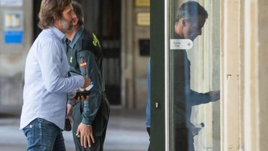 A la izquierda, el capitán condenado con el acusado absuelto (derecha) entran en la Audiencia