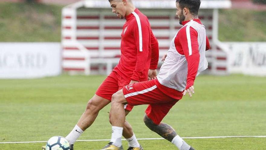 Bertín golpea el balón ante la presión de Rubén García durante el entrenamiento de ayer en Mareo.