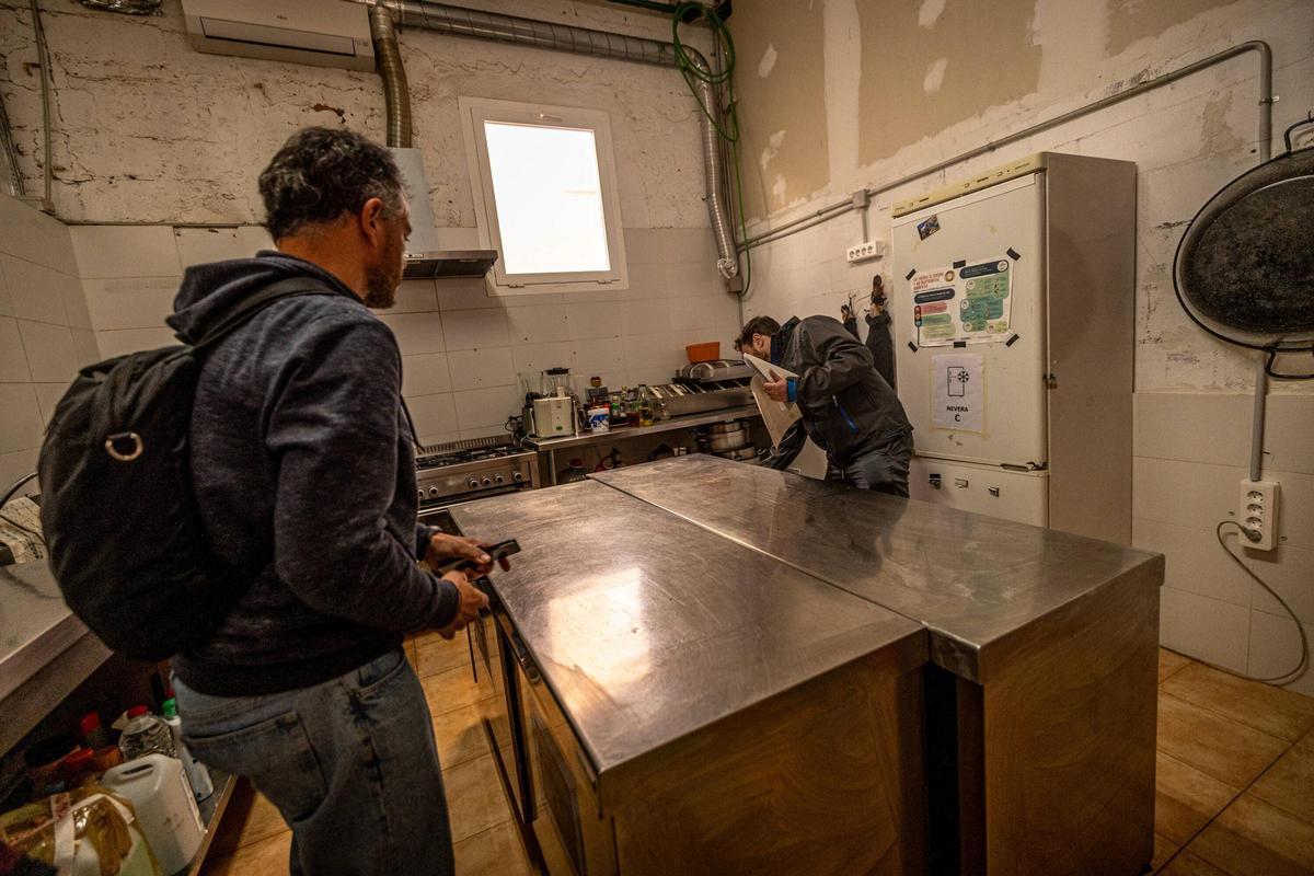 Inspectores del Ayuntamiento de Barcelona examinan la cocina de la ONG Enriquezarte, en el barrio del Turó de la Peira.