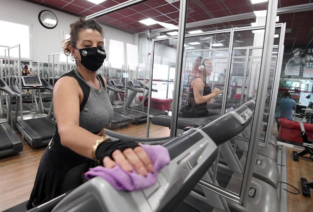 -FOTODELDÍA- EA1865. MILÁN (ITALIA), 19/10/2020.- Una usuaria protegida con mascarilla desinfecta una cinta de correr al final de una sesión de entrenamiento en un gimnasio de Milán, Italia. este lunes. Italia registró 9.338 nuevos contagios de coronavirus en las últimas 24 horas, un aumento menor al de los últimos días pero cuando se hicieron muchas menos pruebas de lo habitual por el fin de semana, según el boletín de hoy el Ministerio de Sanidad. EFE/EPA/DANIEL DAL ZENNARO