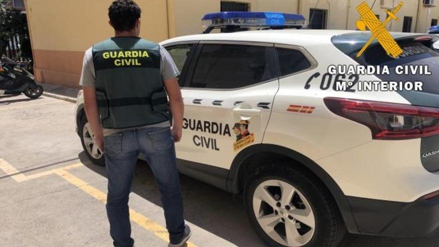 Un agente de la Guardia Civil frente a un vehículo policial