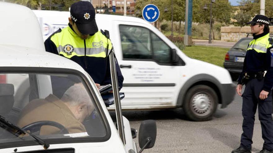 Una pareja de policías locales sancionando a un conductor.