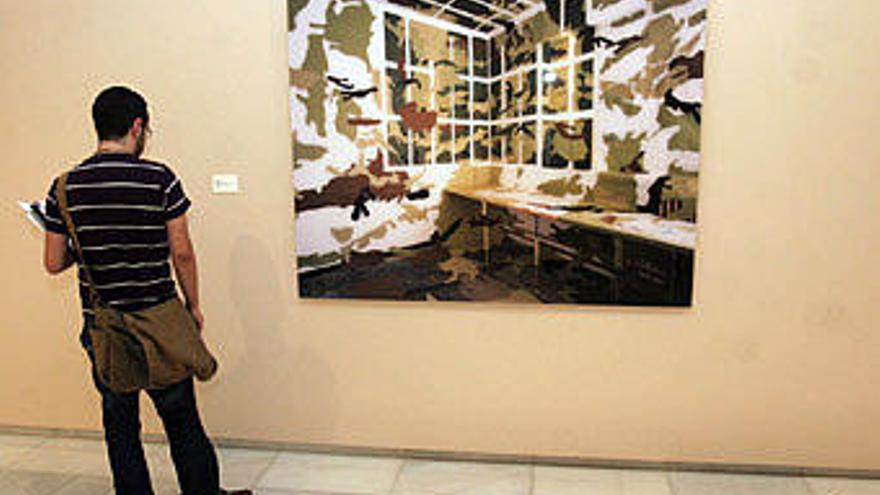 Un joven observa una de las obras seleccionadas en el Certamen de Unicaja de Artes Plásticas.