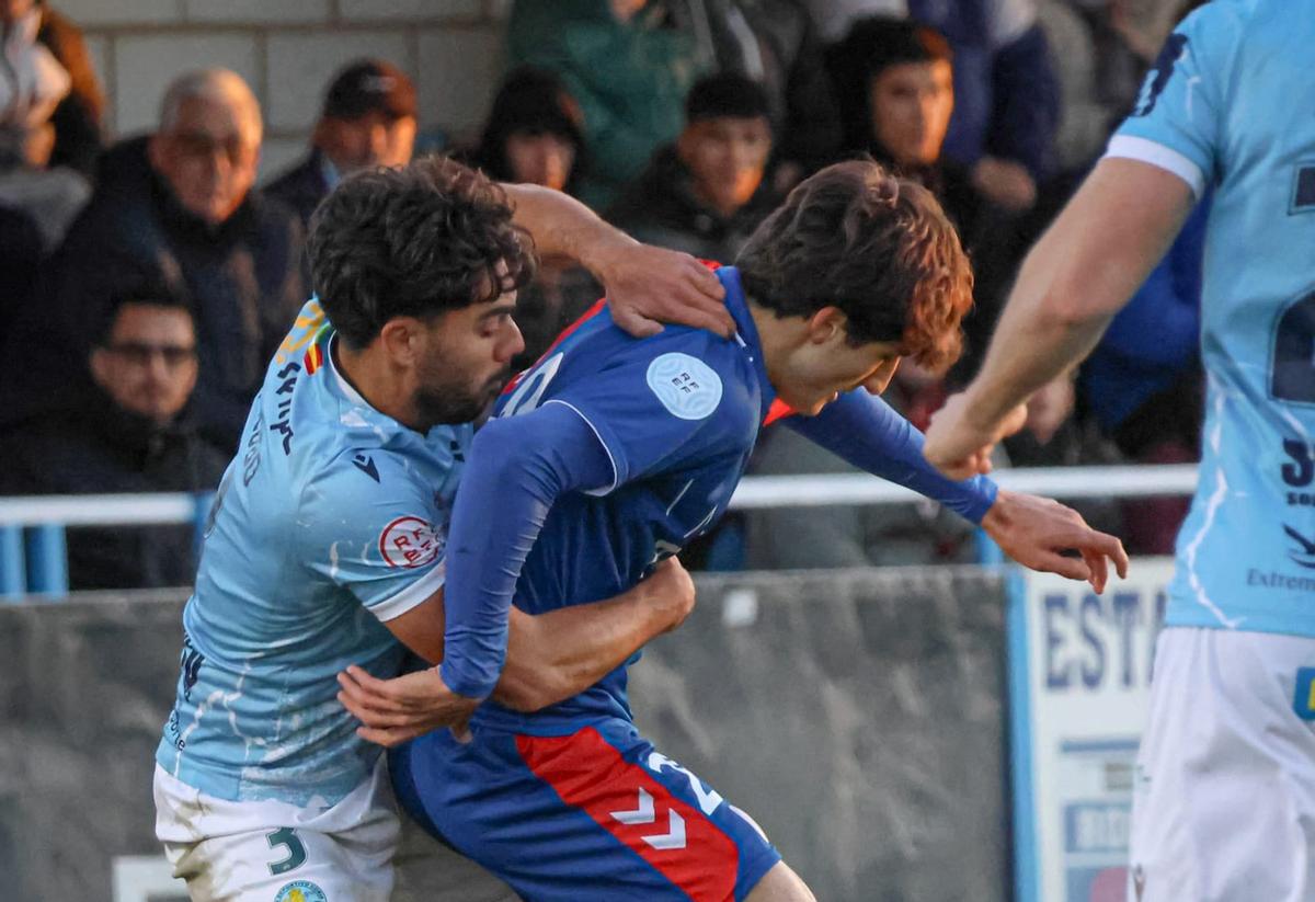 Dos jugadores pugnan por un balón.