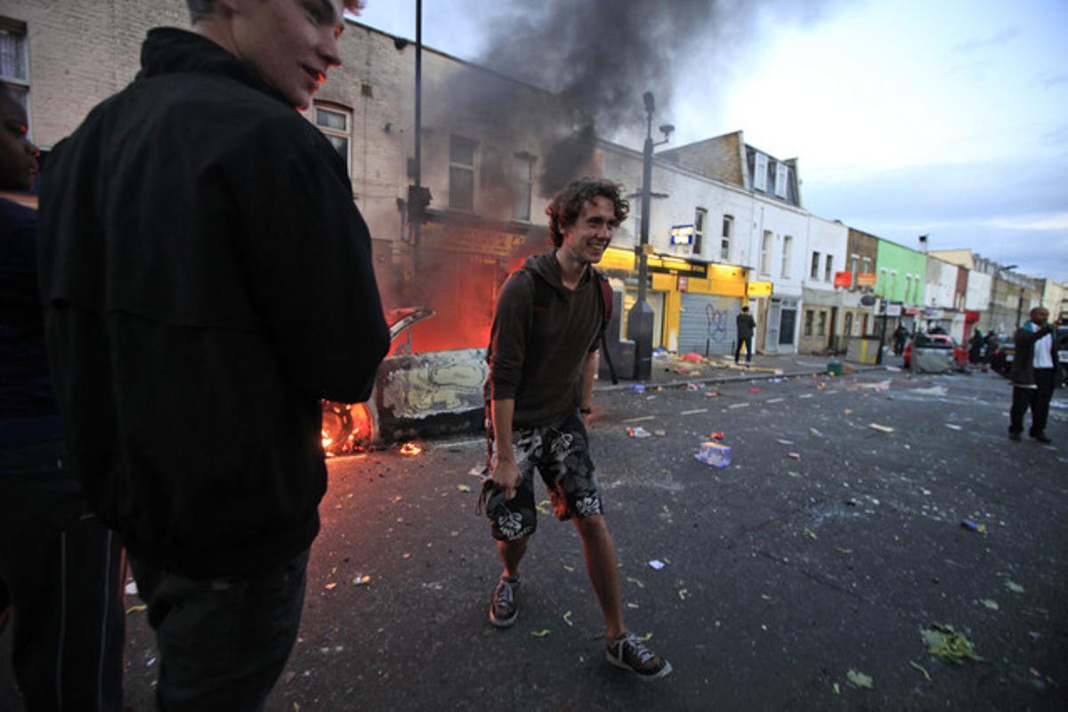 Joves britànics fan broma després de fotografiar un cotxe cremat en els disturbis a Hackney, dilluns a la tarda.
