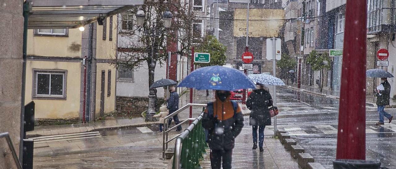 Varias personas se protegen de la nevada de Lalín con paraguas. |   // BERNABÉ/ANA AGRA