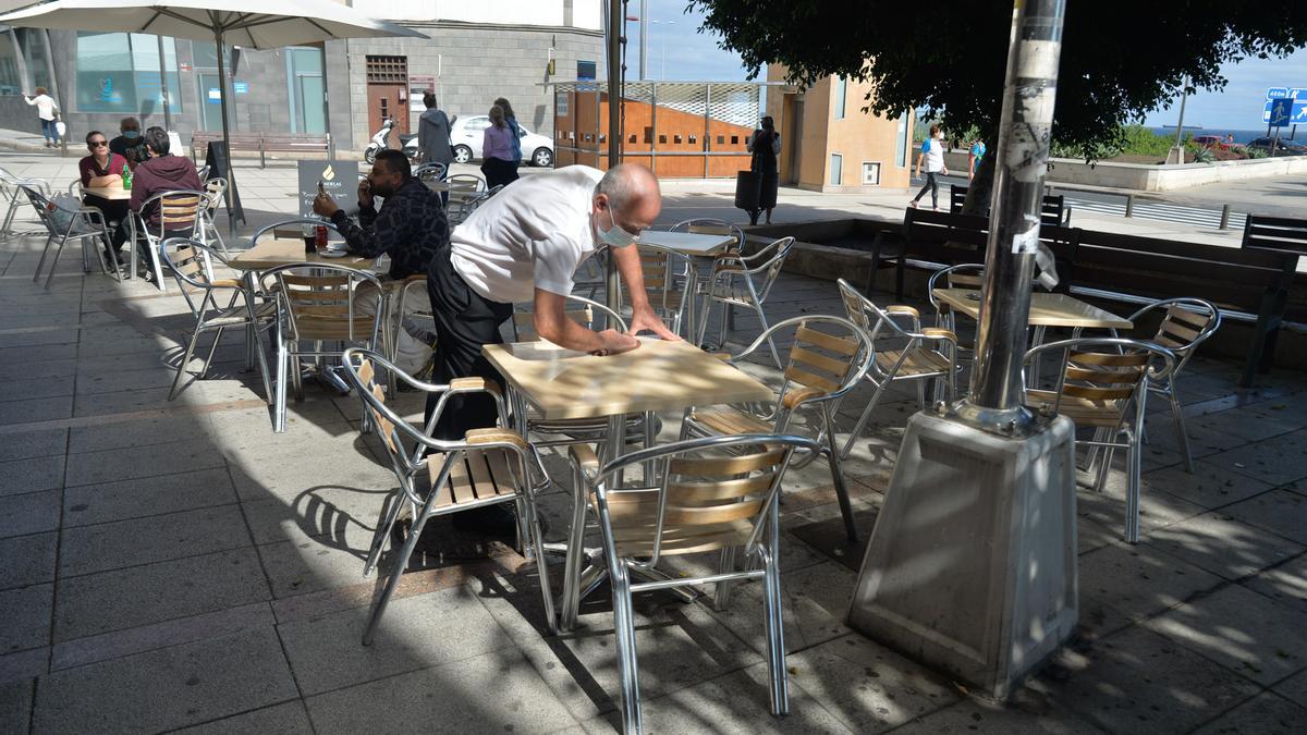 Un camarero limpia una terraza en Las Palmas.