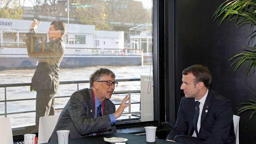 Bill Gates, izquierda, dialoga con Macron a bordo de la embarcación &quot;Mirage&quot;. // Efe