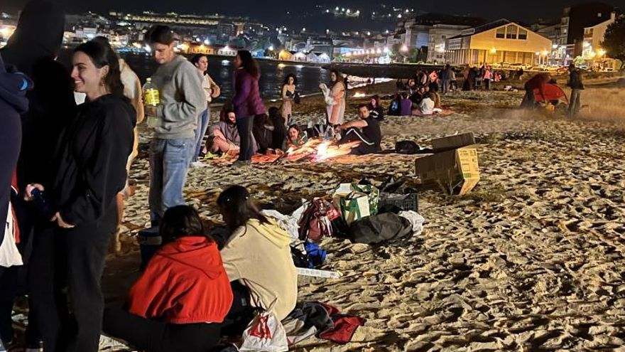 Jóvenes disfrutando de las hogueras y el baño en la playa de Rodeira. | // G.M.P.