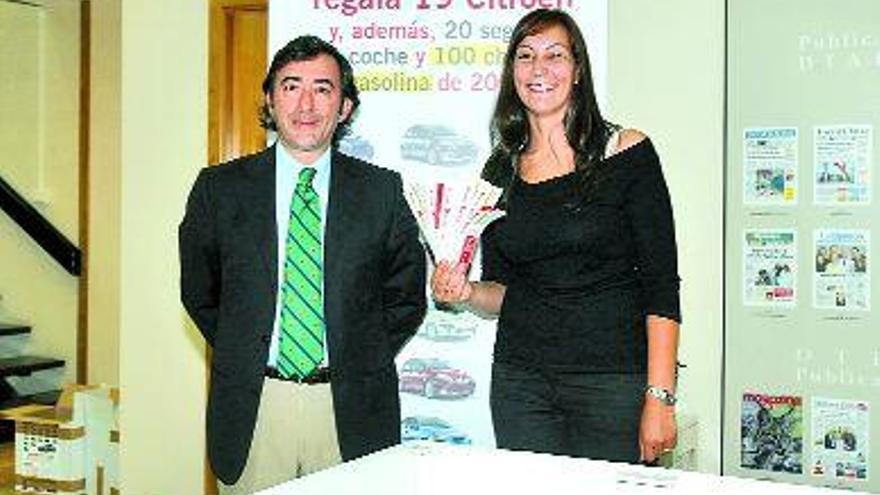 El notario César Casqueiro y Carmen Álvarez, mano inocente del sorteo, muestran los resguardos. / rafa estévez